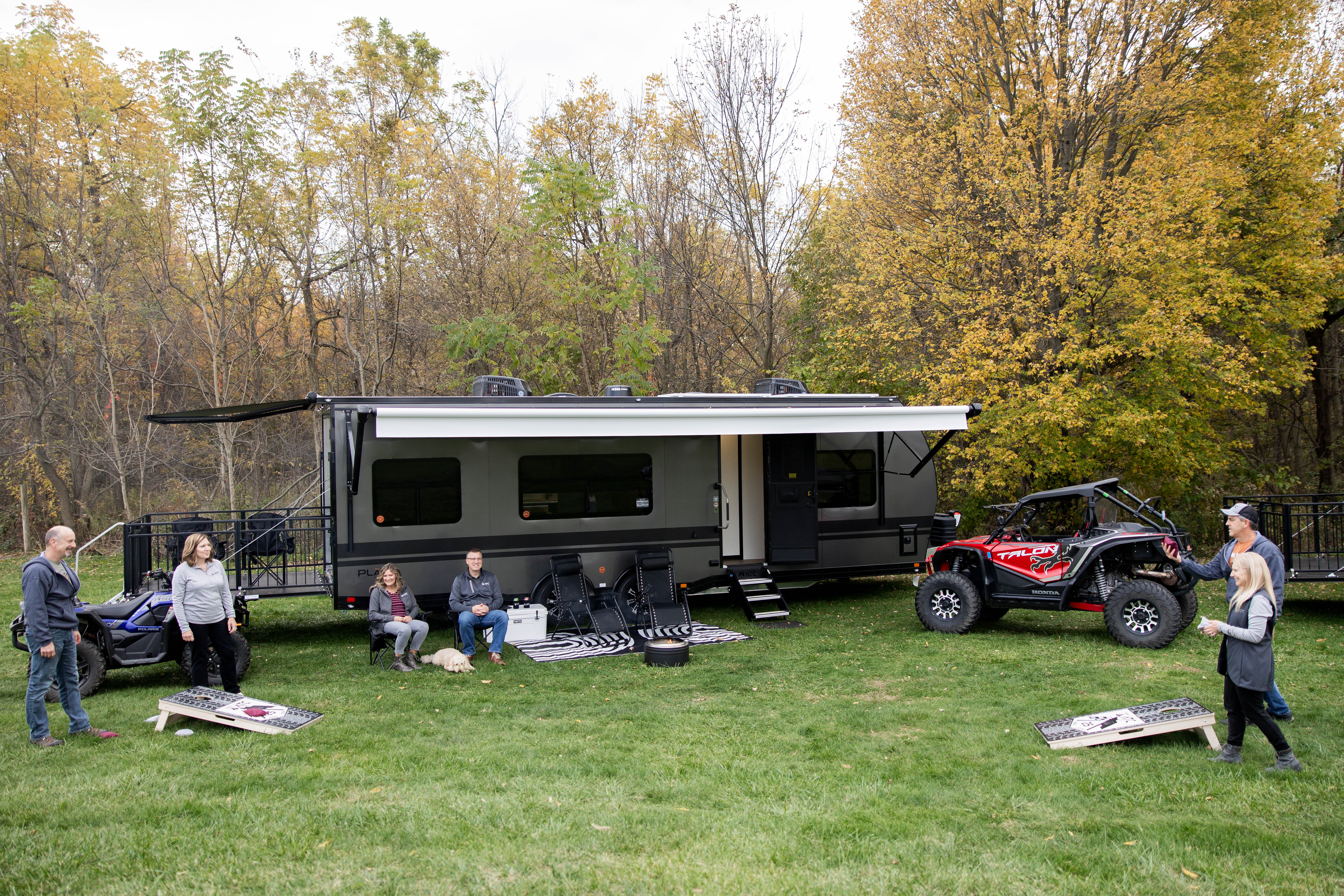 Photo of a group of friend playing yard games in front of an ATC toy hauler.